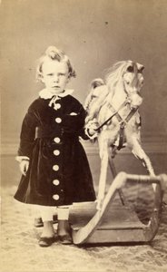 Bambina in piedi vicino a un cavallo a dondolo, 1870s da T. Duryea